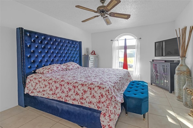 bedroom with a textured ceiling, tile patterned floors, and ceiling fan