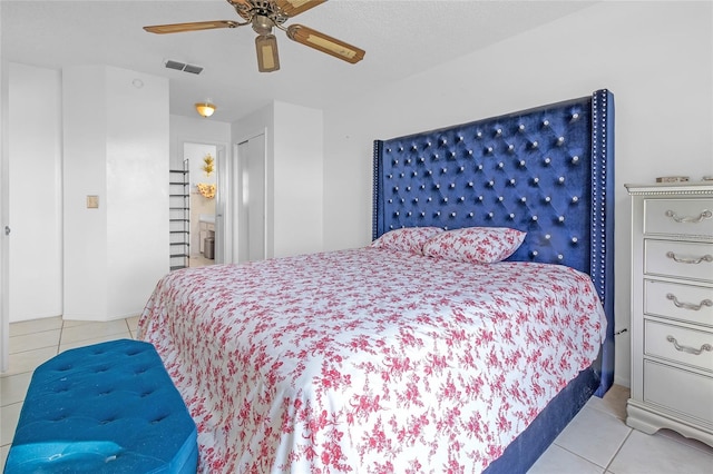 bedroom featuring ceiling fan, a closet, light tile patterned flooring, and ensuite bathroom