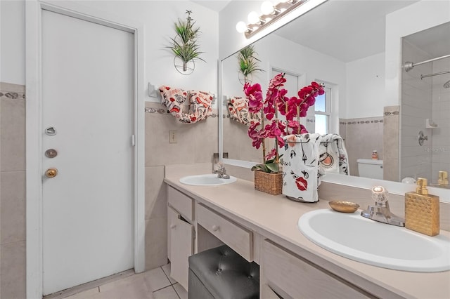 bathroom with vanity, toilet, and tile walls