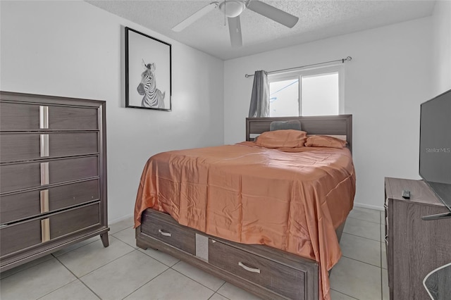 bedroom featuring ceiling fan, light tile patterned flooring, and a textured ceiling