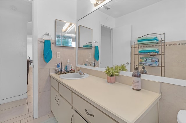 bathroom with tile patterned flooring, vanity, and tile walls