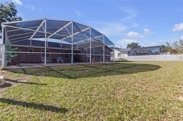 rear view of property with a yard and a lanai