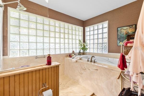 bathroom featuring independent shower and bath and a healthy amount of sunlight