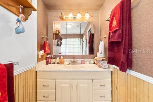 bathroom featuring vanity and wooden walls