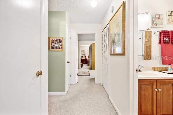 hallway with sink and a textured ceiling