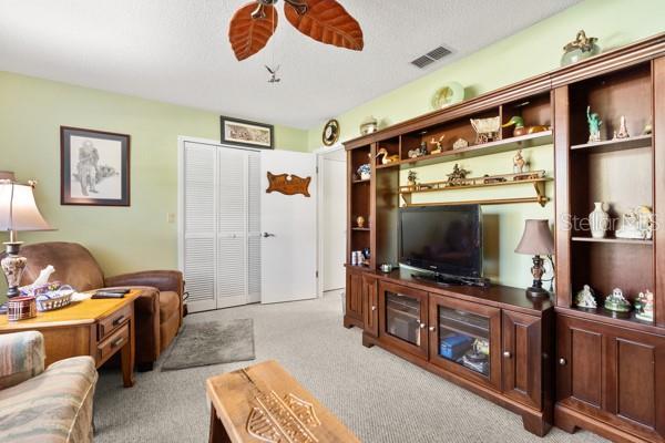 living room featuring ceiling fan and light colored carpet