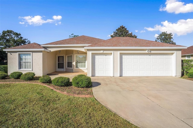 single story home with a garage and a front lawn