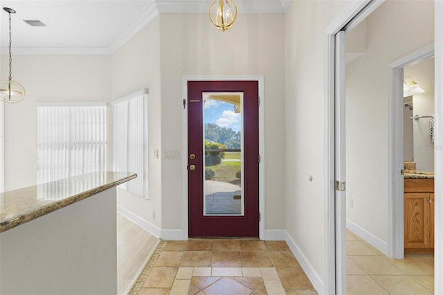 entrance foyer with a chandelier and ornamental molding