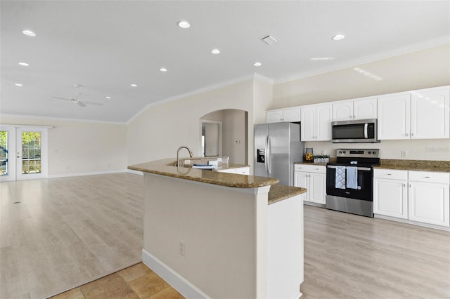 kitchen with ceiling fan, stainless steel appliances, dark stone countertops, white cabinets, and ornamental molding