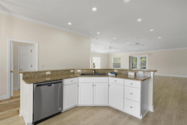 kitchen featuring white cabinetry, sink, stainless steel dishwasher, dark stone countertops, and light hardwood / wood-style floors