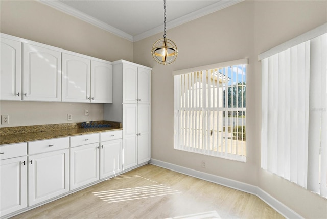 kitchen with hanging light fixtures, an inviting chandelier, light wood-type flooring, white cabinets, and ornamental molding