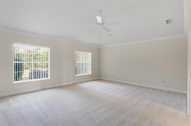 carpeted empty room with crown molding, ceiling fan, and a healthy amount of sunlight