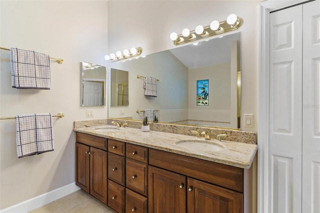 bathroom featuring tile patterned floors, a tub, and vanity