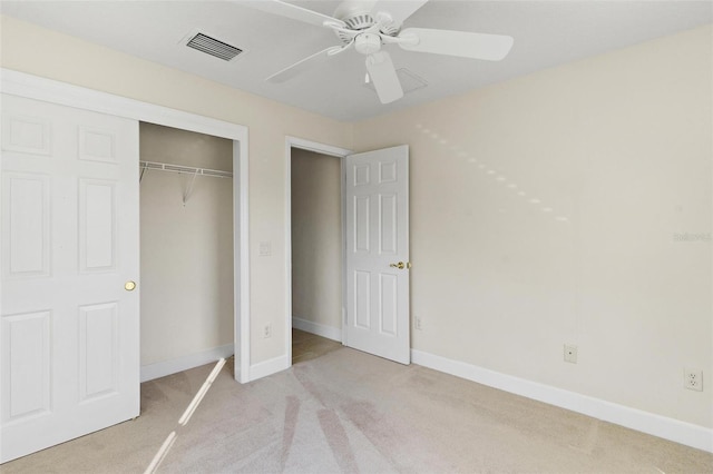 unfurnished bedroom with ceiling fan, a closet, and light carpet