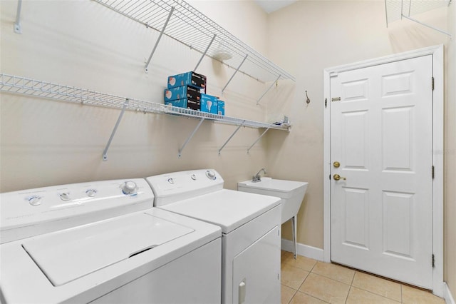 laundry room featuring separate washer and dryer and light tile patterned flooring