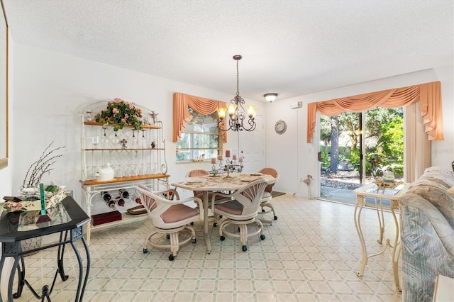 dining room with a textured ceiling and a chandelier