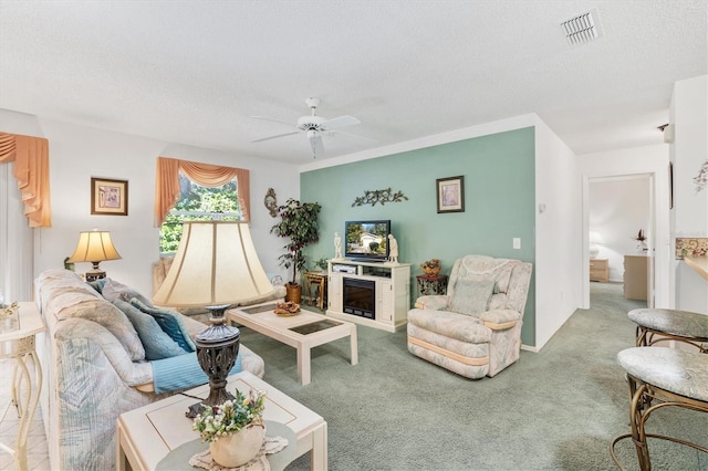 carpeted living room featuring a textured ceiling and ceiling fan