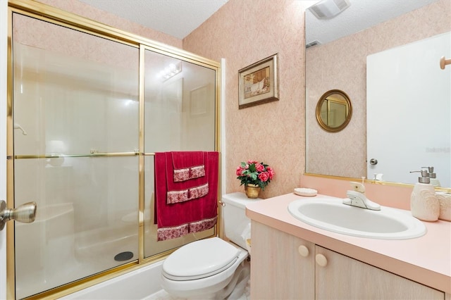 bathroom with a shower with door, vanity, a textured ceiling, and toilet