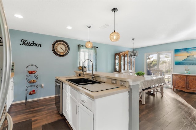 kitchen featuring dark wood-type flooring, sink, an island with sink, and pendant lighting