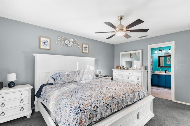 bedroom with carpet floors, ensuite bathroom, and ceiling fan