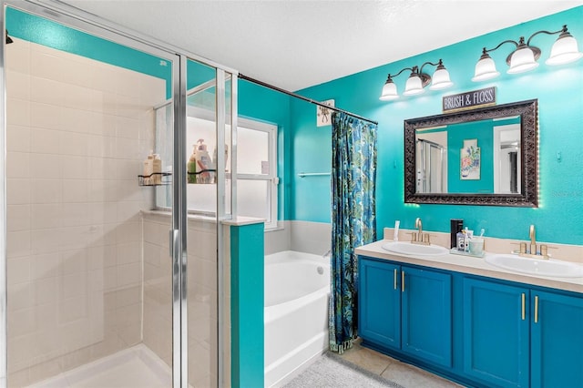 bathroom featuring tile patterned floors, vanity, a textured ceiling, and independent shower and bath