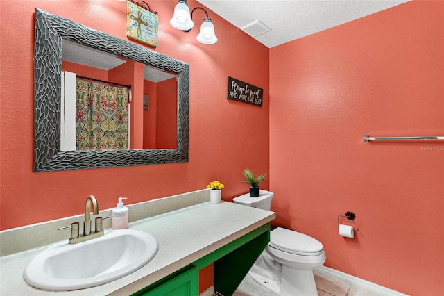 bathroom featuring vanity, a textured ceiling, tile patterned floors, and toilet