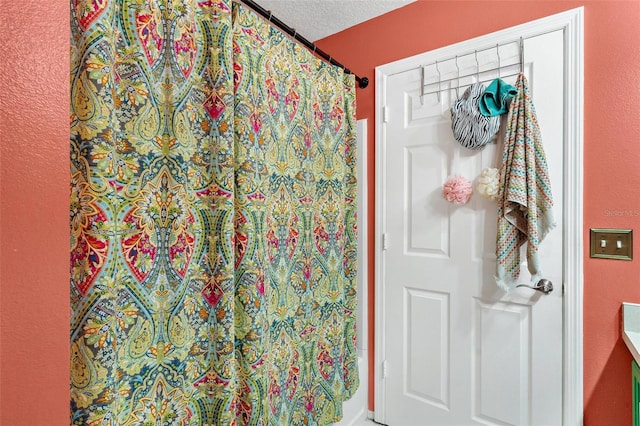 bathroom featuring vanity, a textured ceiling, and shower / tub combo