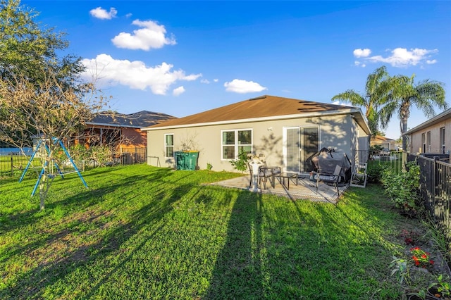 rear view of property featuring a patio area, a playground, and a yard