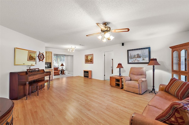 living room featuring a textured ceiling, light hardwood / wood-style flooring, and ceiling fan