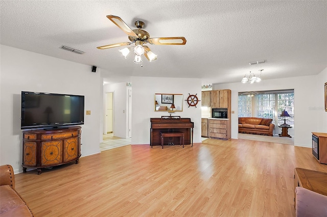 living room with ceiling fan with notable chandelier, a textured ceiling, and light hardwood / wood-style floors