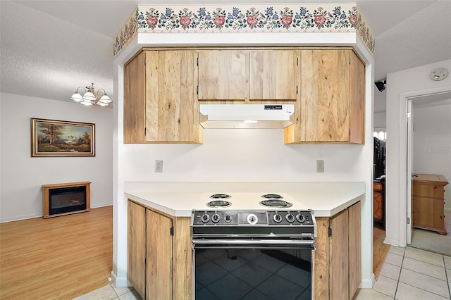 kitchen with light hardwood / wood-style flooring, black electric range oven, and a textured ceiling