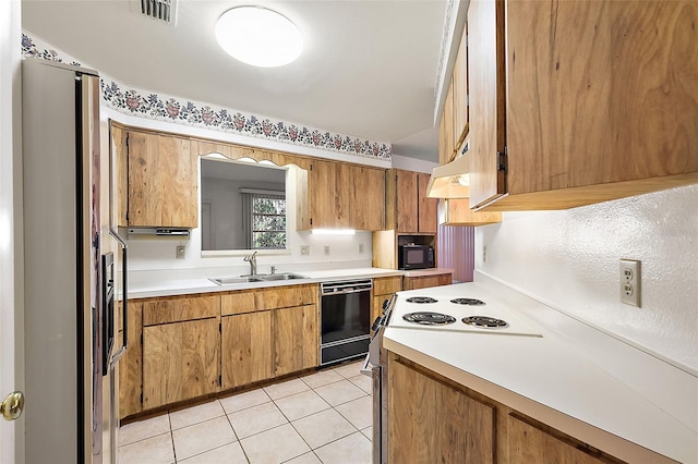 kitchen with light tile patterned floors, sink, and black appliances