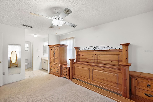 carpeted bedroom featuring a textured ceiling, connected bathroom, ceiling fan, and multiple windows