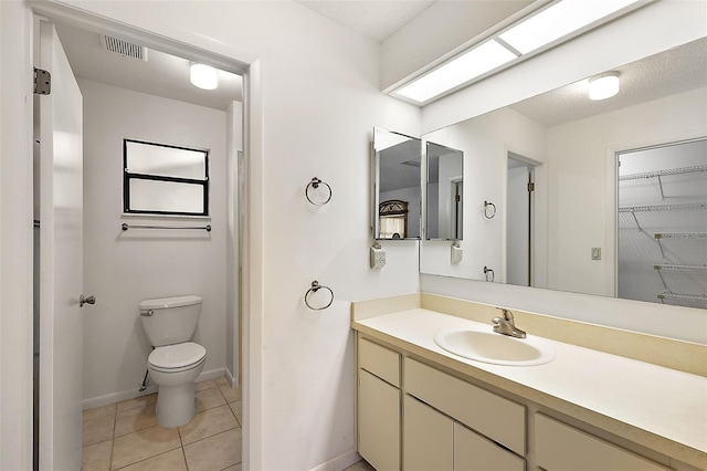 bathroom with tile patterned flooring, vanity, and toilet