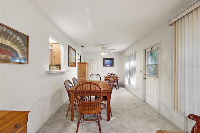 carpeted dining room featuring ceiling fan