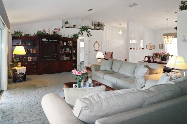 living room with carpet, an inviting chandelier, and vaulted ceiling