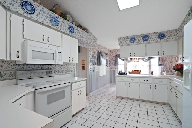 kitchen with lofted ceiling, white cabinetry, light tile patterned flooring, and white appliances