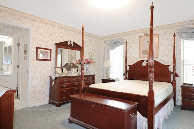 bedroom featuring a textured ceiling and light colored carpet