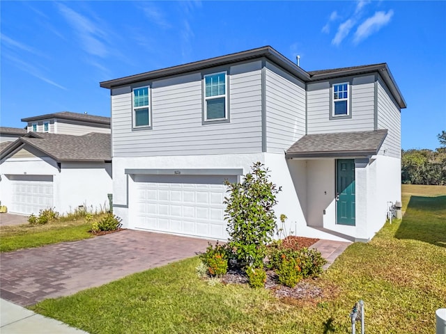 view of property featuring a garage and a front lawn