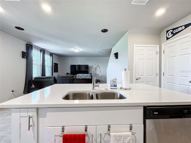 kitchen featuring dishwasher, white cabinets, a kitchen island with sink, and sink