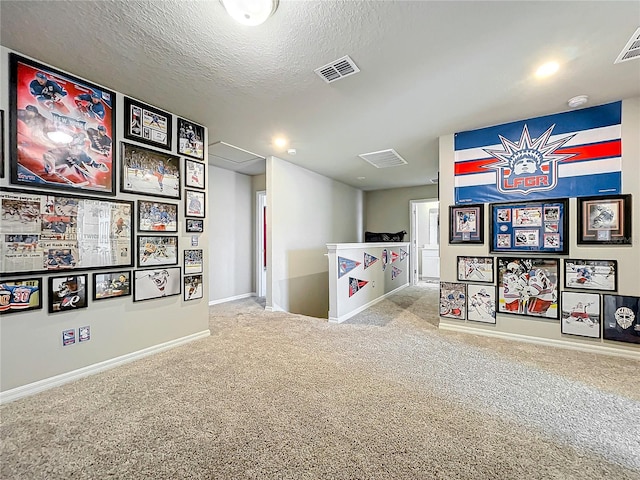 playroom featuring a textured ceiling and carpet floors