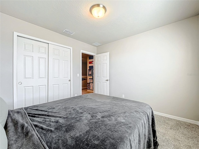 bedroom featuring carpet, a textured ceiling, and a closet