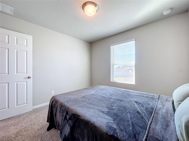 carpeted bedroom with a textured ceiling