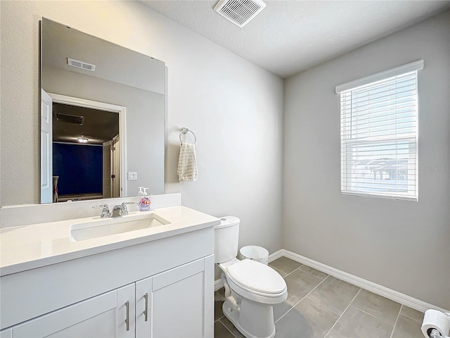 bathroom featuring tile patterned flooring, a textured ceiling, vanity, and toilet