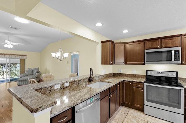 kitchen with kitchen peninsula, stainless steel appliances, stone countertops, and light hardwood / wood-style floors