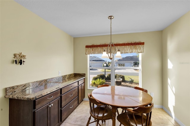 tiled dining space featuring an inviting chandelier