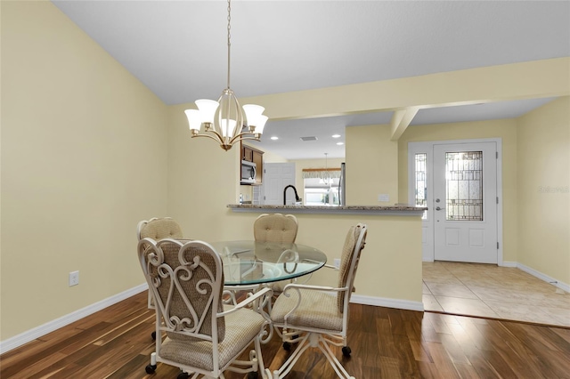 dining space featuring a chandelier, hardwood / wood-style flooring, and sink