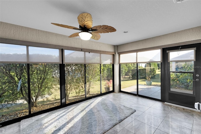 unfurnished sunroom with ceiling fan