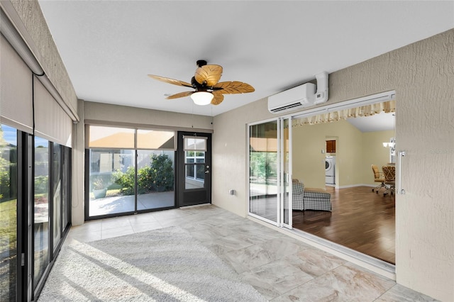 unfurnished room featuring washer / clothes dryer, a wealth of natural light, light hardwood / wood-style floors, and a wall mounted air conditioner