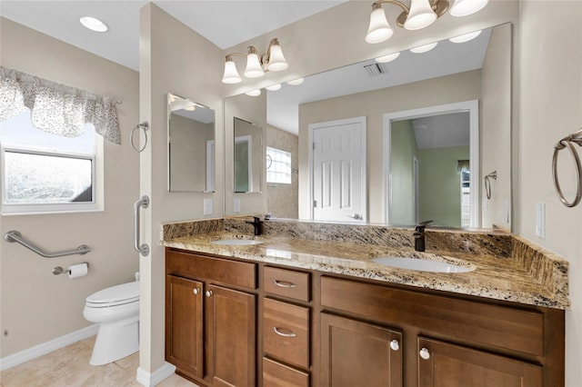 bathroom featuring vanity, toilet, and a notable chandelier